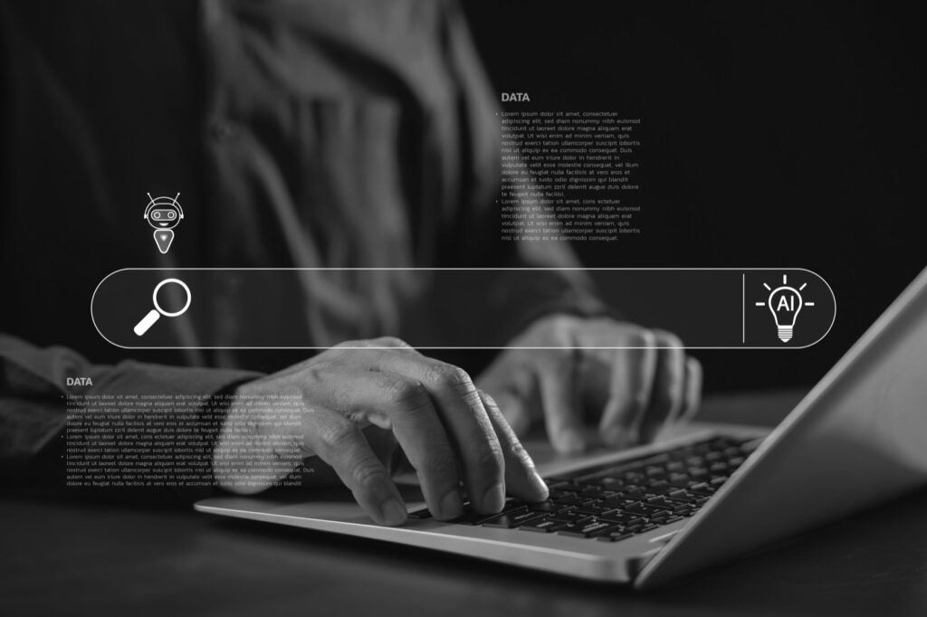 Mains tapant sur un ordinateur portable devant une interface de recherche IA